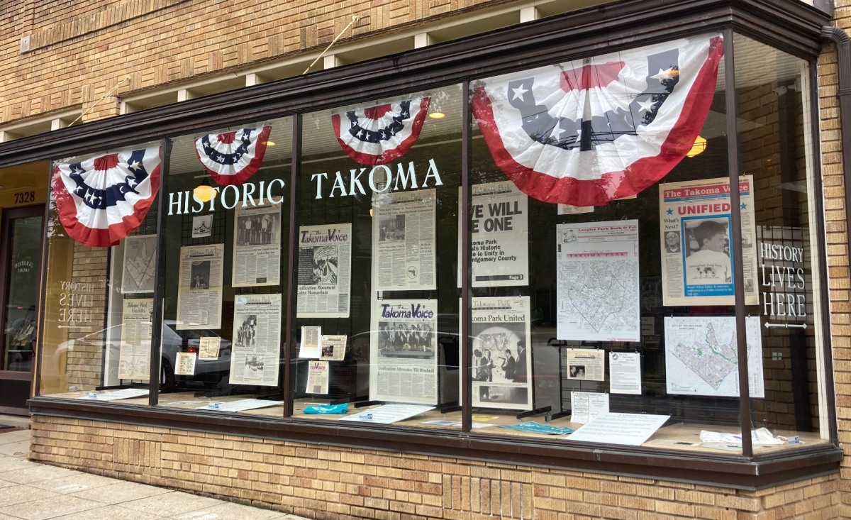 Historic Takoma storefront window displaying the Unification exhibit.