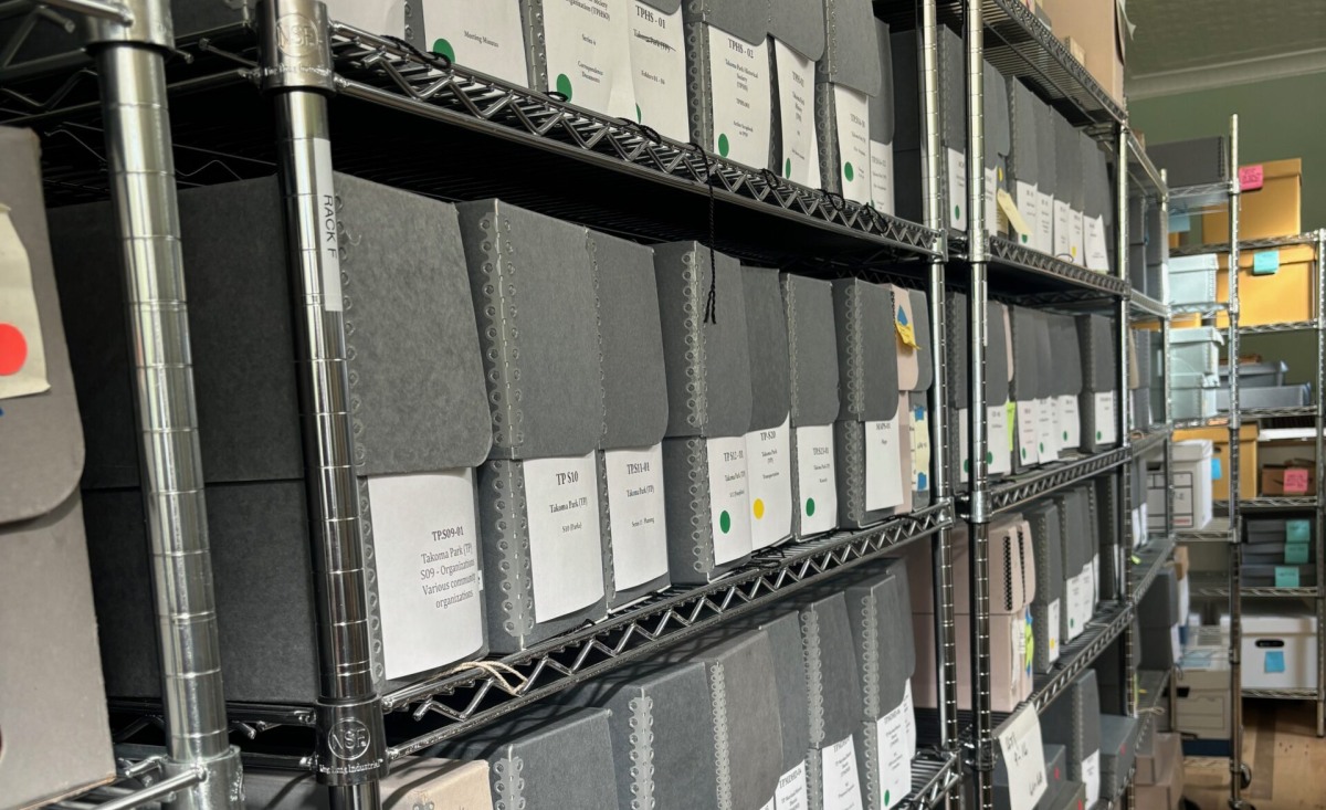 Historic Takoma archive boxes arranged on metal shelves.