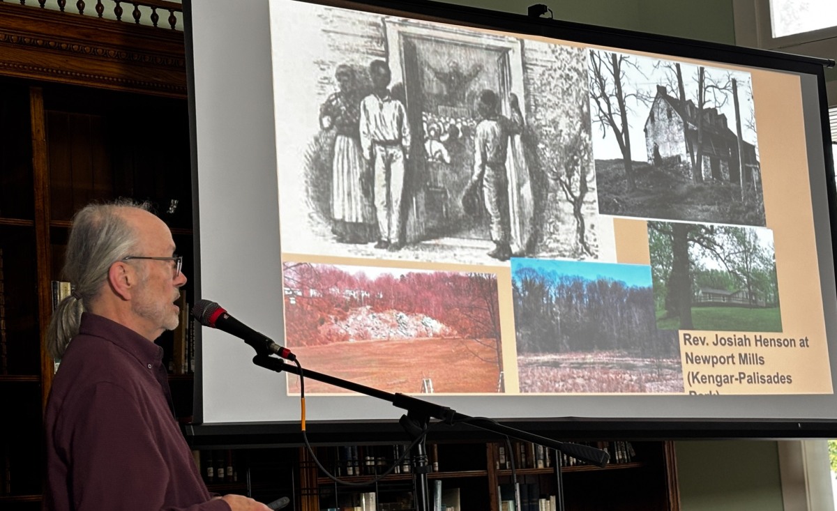 Speaker at a microphone presenting historical images at Historic Takoma.